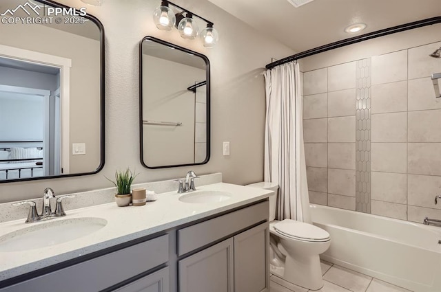 bathroom with shower / tub combo, double vanity, a sink, and tile patterned flooring