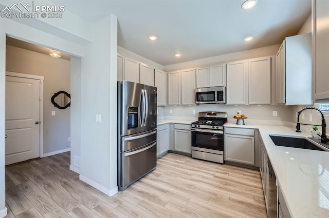 kitchen with a sink, light wood-style flooring, recessed lighting, and stainless steel appliances