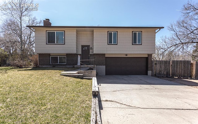 split foyer home featuring fence, a front lawn, a chimney, a garage, and driveway