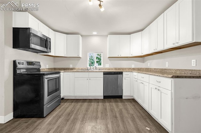 738 Harrison Pl, Colorado Springs, CO 80905 - kitchen with stainless steel appliances, light wood-style floors, white cabinetry, and recessed lighting
