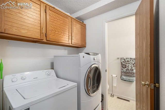 laundry area with light floors, washer and clothes dryer, visible vents, cabinet space, and a textured ceiling