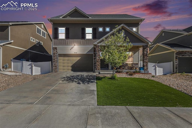 view of front of house featuring an attached garage, a front lawn, stone siding, board and batten siding, and driveway