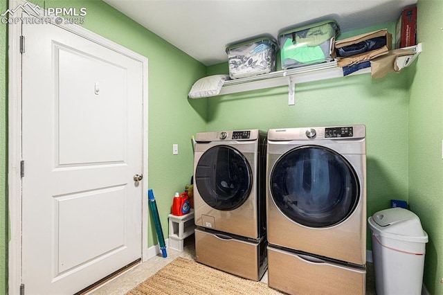 washroom with washing machine and clothes dryer, laundry area, and baseboards