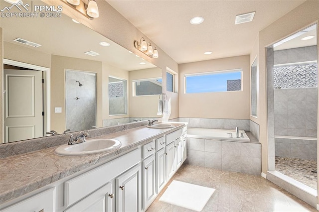 bathroom featuring visible vents, a sink, a tile shower, and double vanity