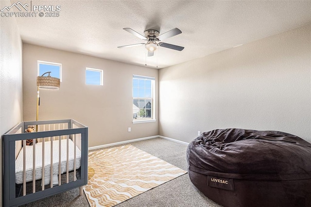 carpeted bedroom featuring baseboards, a textured ceiling, and ceiling fan