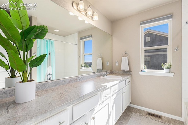 bathroom with visible vents, baseboards, a shower with shower curtain, and vanity