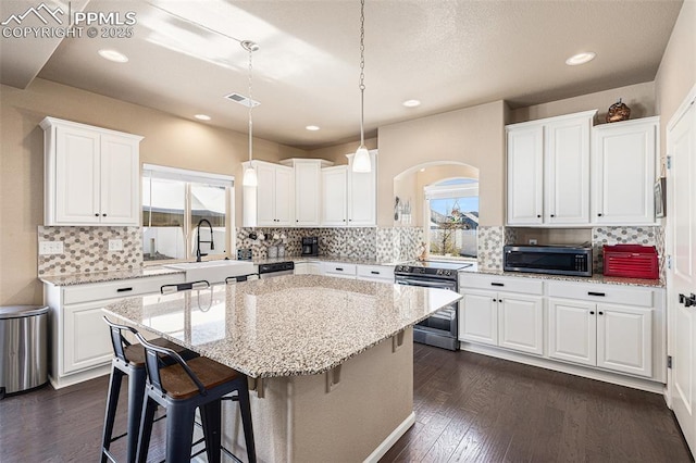 kitchen with backsplash, stainless steel appliances, visible vents, and a sink