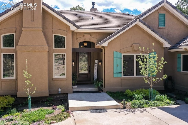 18383 Lazy Summer Way, Monument, CO 80132 - property entrance featuring stucco siding, a chimney, and a tile roof