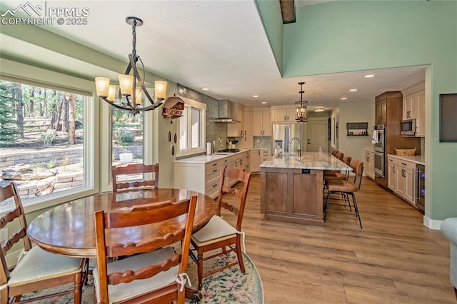 18383 Lazy Summer Way, Monument, CO 80132 - dining area with a chandelier, wine cooler, light wood-style floors, and recessed lighting