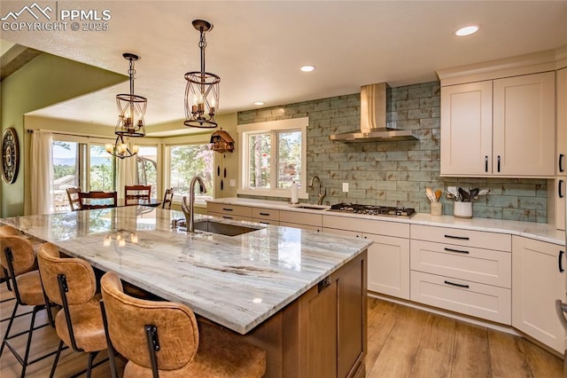 18383 Lazy Summer Way, Monument, CO 80132 - kitchen featuring a sink, wall chimney range hood, stainless steel gas stovetop, backsplash, and recessed lighting