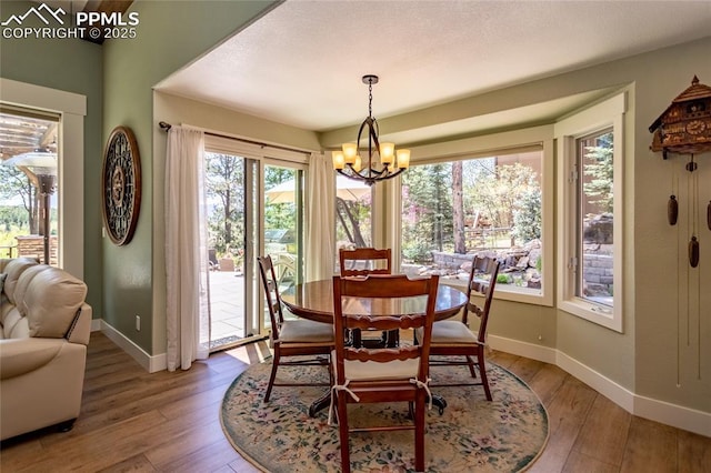 18383 Lazy Summer Way, Monument, CO 80132 - dining space featuring baseboards, light wood-style flooring, and a chandelier