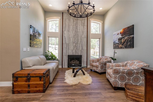 18383 Lazy Summer Way, Monument, CO 80132 - living area with a chandelier, healthy amount of natural light, wood finished floors, a high end fireplace, and a high ceiling