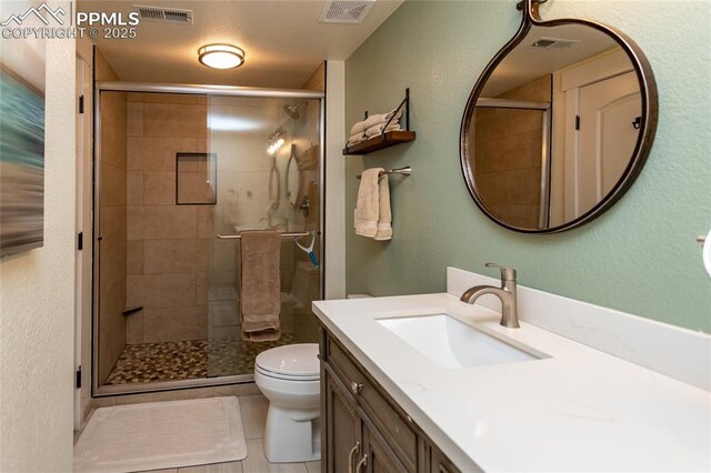 18383 Lazy Summer Way, Monument, CO 80132 - bathroom featuring vanity, toilet, a shower stall, and a textured wall