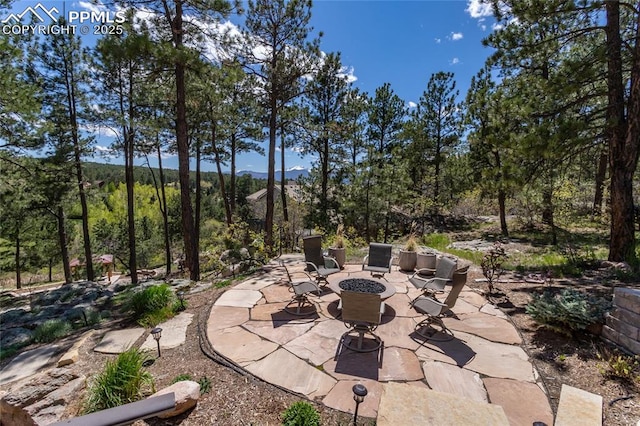 18383 Lazy Summer Way, Monument, CO 80132 - view of patio / terrace featuring an outdoor fire pit and a wooded view