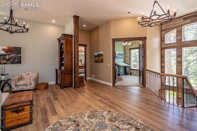 18383 Lazy Summer Way, Monument, CO 80132 - living area with a chandelier, a high ceiling, light wood-style floors, plenty of natural light, and baseboards
