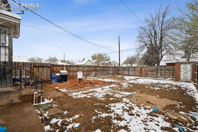 yard covered in snow with an outdoor structure and a fenced backyard