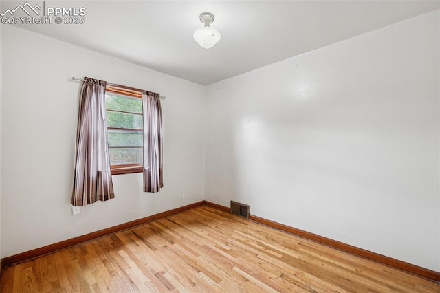 unfurnished room featuring light wood-style floors, baseboards, and visible vents