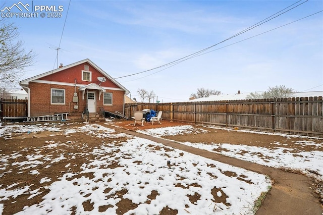 exterior space with entry steps, a fenced backyard, and brick siding