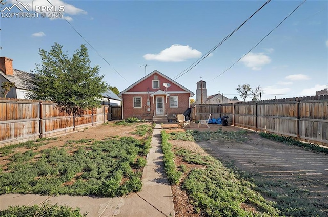 exterior space featuring a fenced backyard and brick siding
