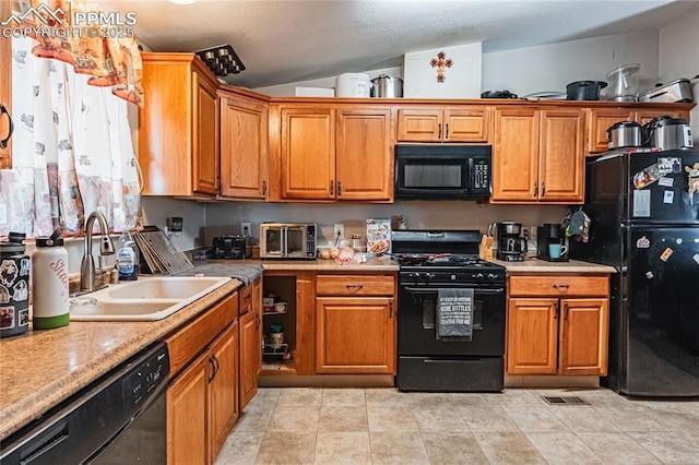 735 E Vermijo Ave, Colorado Springs, CO 80903 - kitchen with brown cabinets, vaulted ceiling, a sink, and black appliances