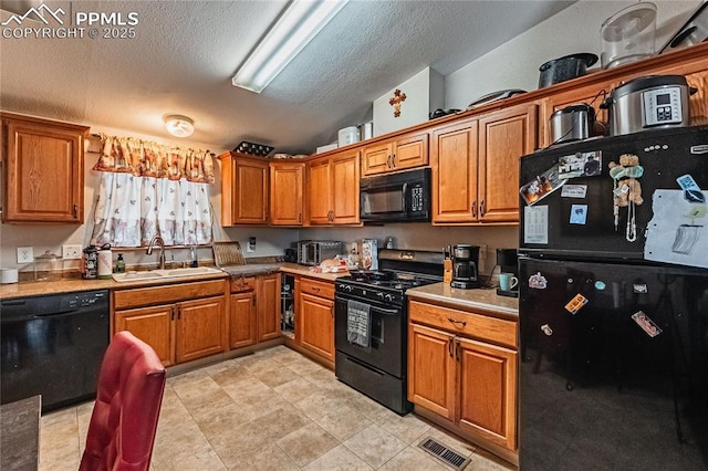 735 E Vermijo Ave, Colorado Springs, CO 80903 - kitchen featuring brown cabinets, lofted ceiling, a sink, black appliances, and a textured ceiling