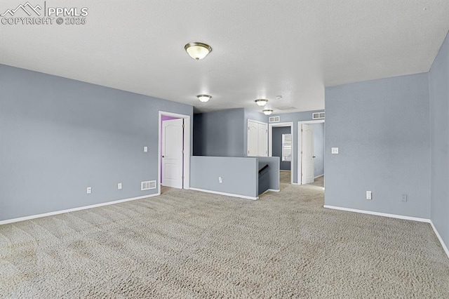 spare room with baseboards, carpet flooring, and visible vents