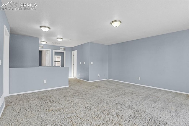 carpeted spare room with baseboards and visible vents