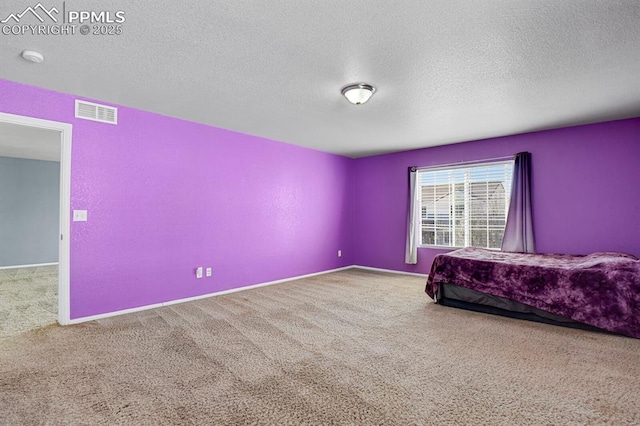 bedroom with visible vents, carpet floors, and a textured ceiling