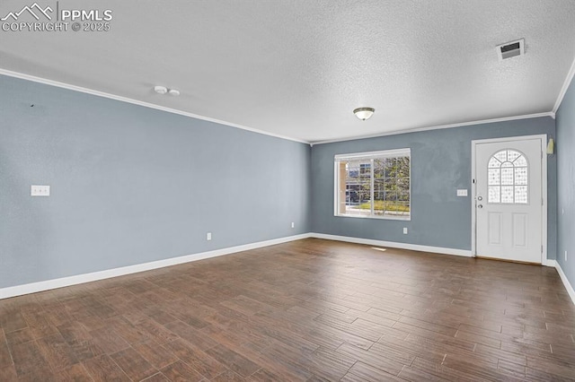 entrance foyer featuring dark wood-type flooring, a wealth of natural light, baseboards, and ornamental molding