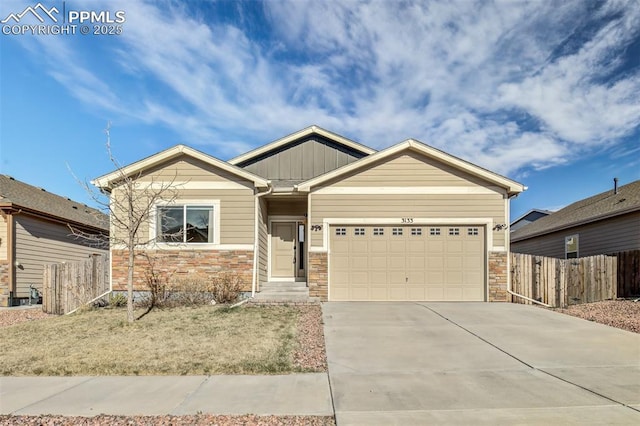 craftsman-style home featuring driveway, stone siding, board and batten siding, an attached garage, and fence