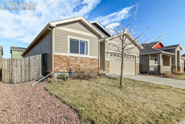craftsman house featuring driveway, stone siding, an attached garage, a front lawn, and fence