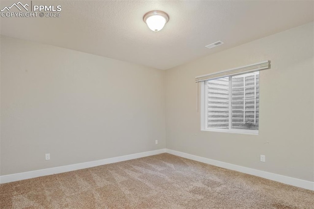carpeted spare room featuring baseboards and visible vents