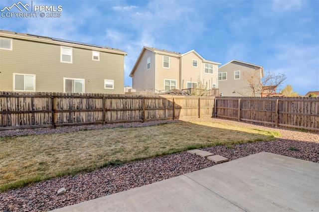 view of yard featuring a patio area, a residential view, and a fenced backyard