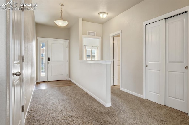 carpeted entrance foyer featuring visible vents and baseboards