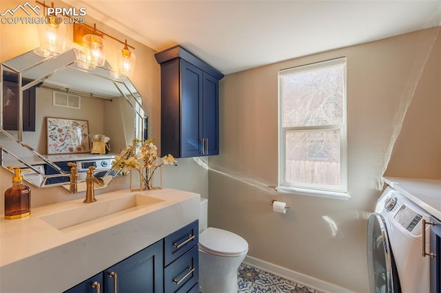 bathroom featuring vanity, visible vents, washer and dryer, toilet, and baseboards