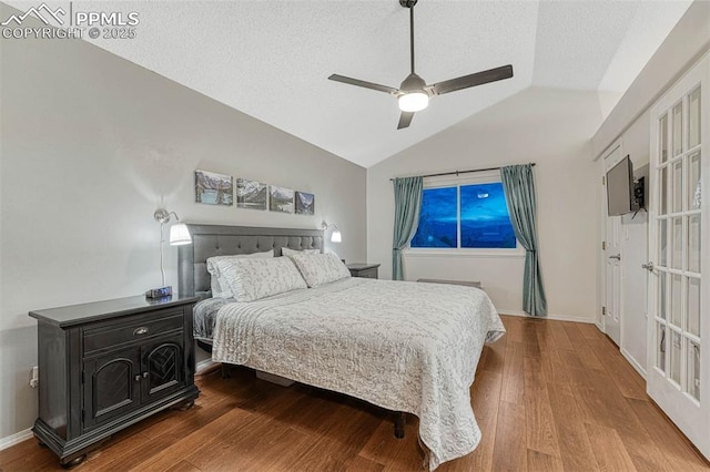 bedroom featuring wood finished floors, lofted ceiling, baseboards, a textured ceiling, and a ceiling fan