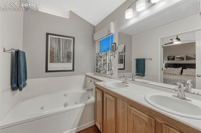bathroom with a tub with jets, a sink, and double vanity
