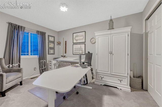 carpeted home office with baseboards and a textured ceiling