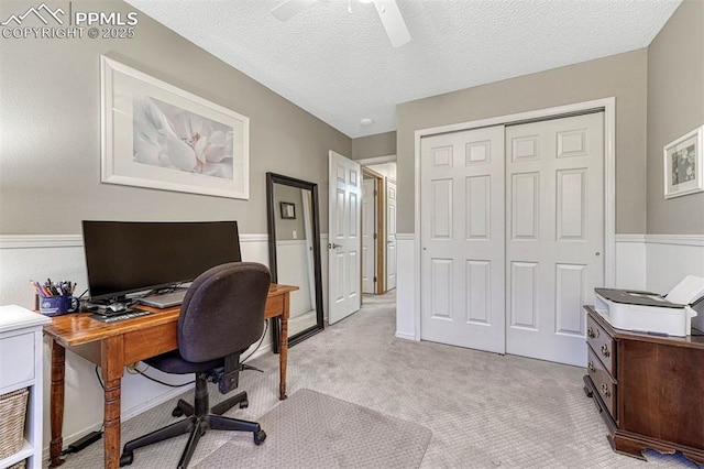 office space with a textured ceiling, ceiling fan, and light carpet