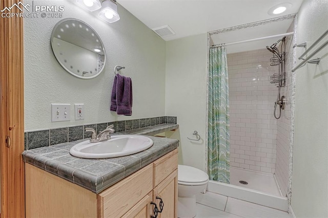 bathroom featuring tile patterned flooring, visible vents, vanity, toilet, and a stall shower