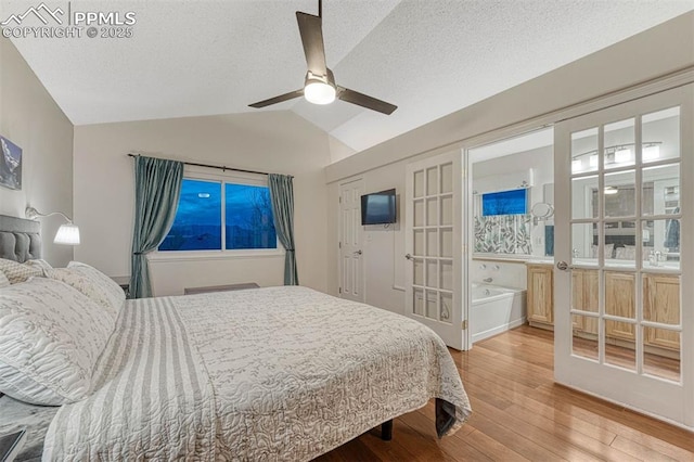 bedroom featuring ceiling fan, vaulted ceiling, hardwood / wood-style flooring, and a textured ceiling