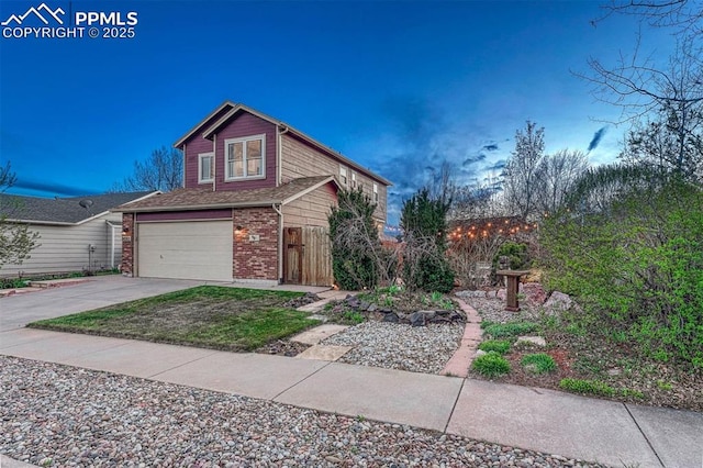 traditional home with fence, an attached garage, driveway, and brick siding