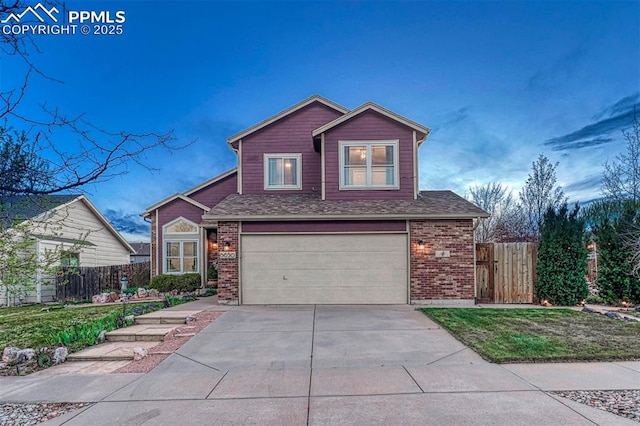 traditional-style home featuring brick siding, a garage, fence, and driveway