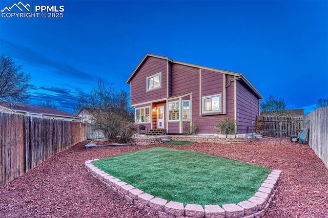 back of property with a yard and a fenced backyard