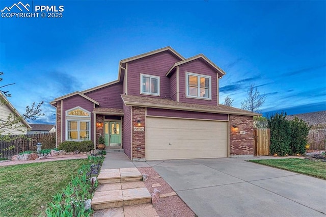 traditional home featuring brick siding, fence, driveway, and a garage
