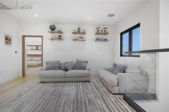 living room with recessed lighting, wood finished floors, and visible vents