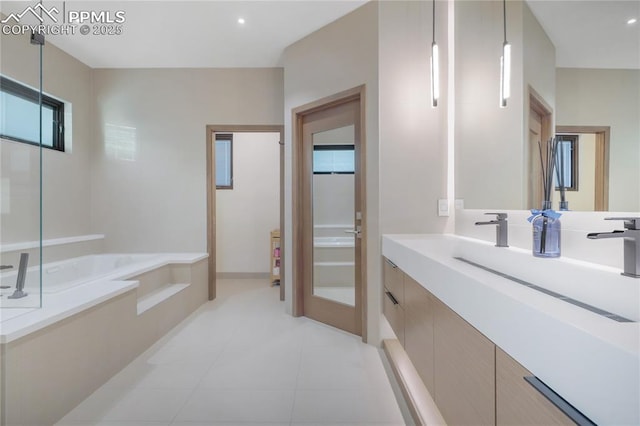 full bath featuring a garden tub, vanity, and tile patterned floors