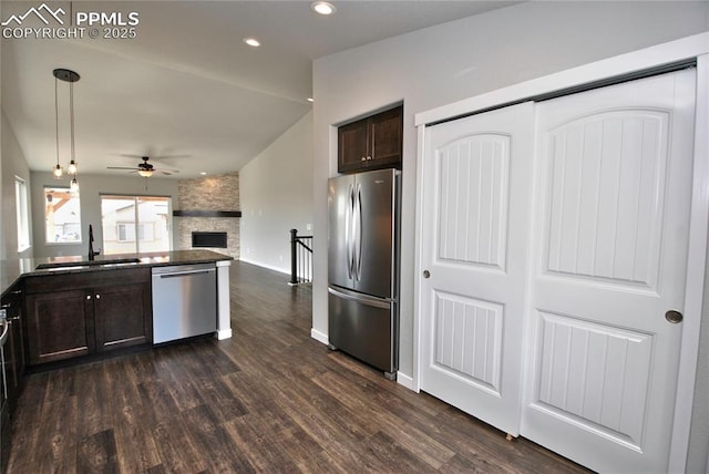 kitchen with open floor plan, dark brown cabinets, ceiling fan, stainless steel appliances, and a sink