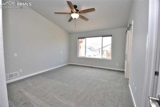 spare room with visible vents, baseboards, ceiling fan, vaulted ceiling, and carpet flooring
