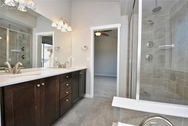 full bathroom with double vanity, a stall shower, tile patterned floors, ceiling fan, and a sink